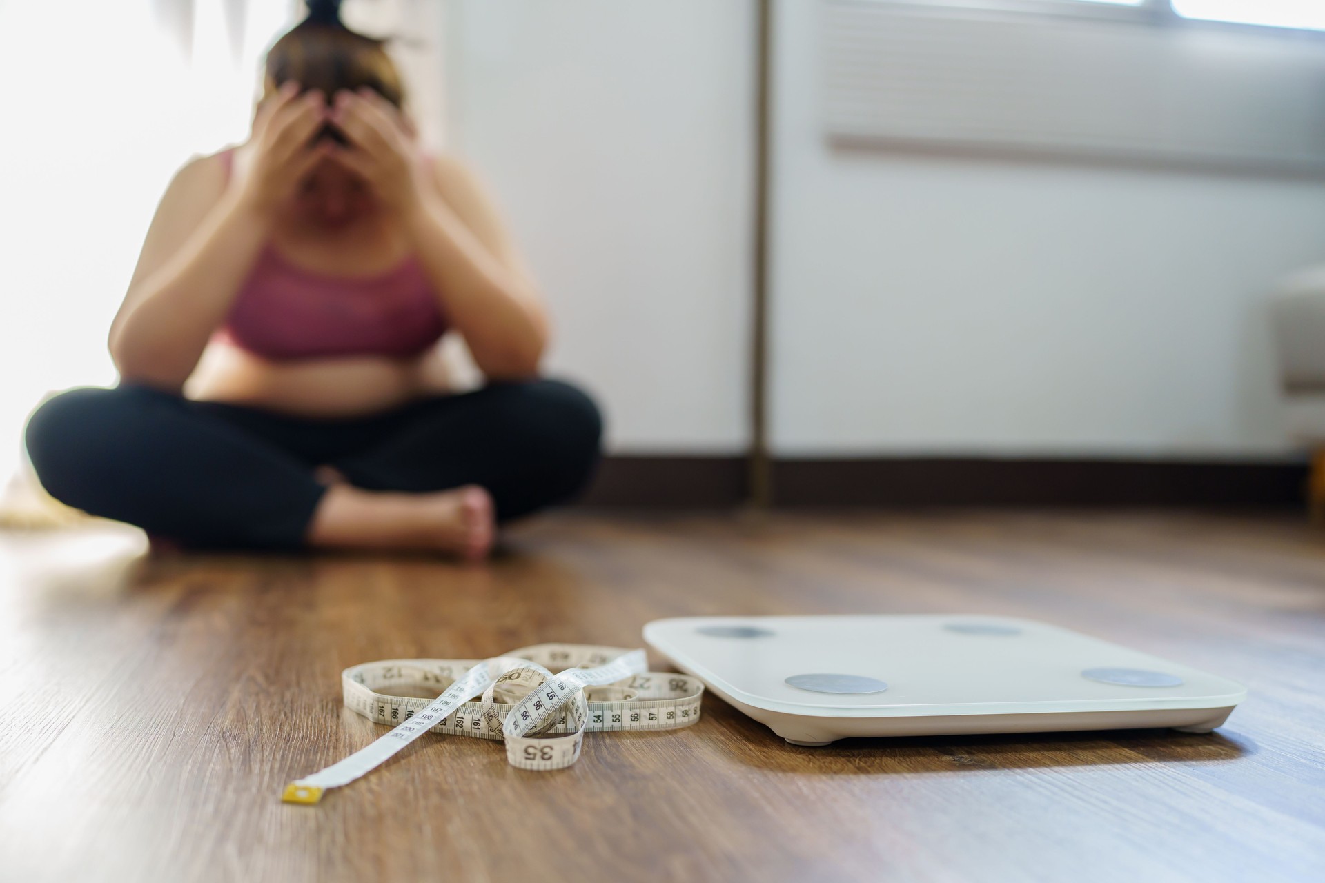 Obese Woman with fat upset bored of dieting Weight loss failÂ  Fat diet and scale sad asian woman on weight scale at home weight control